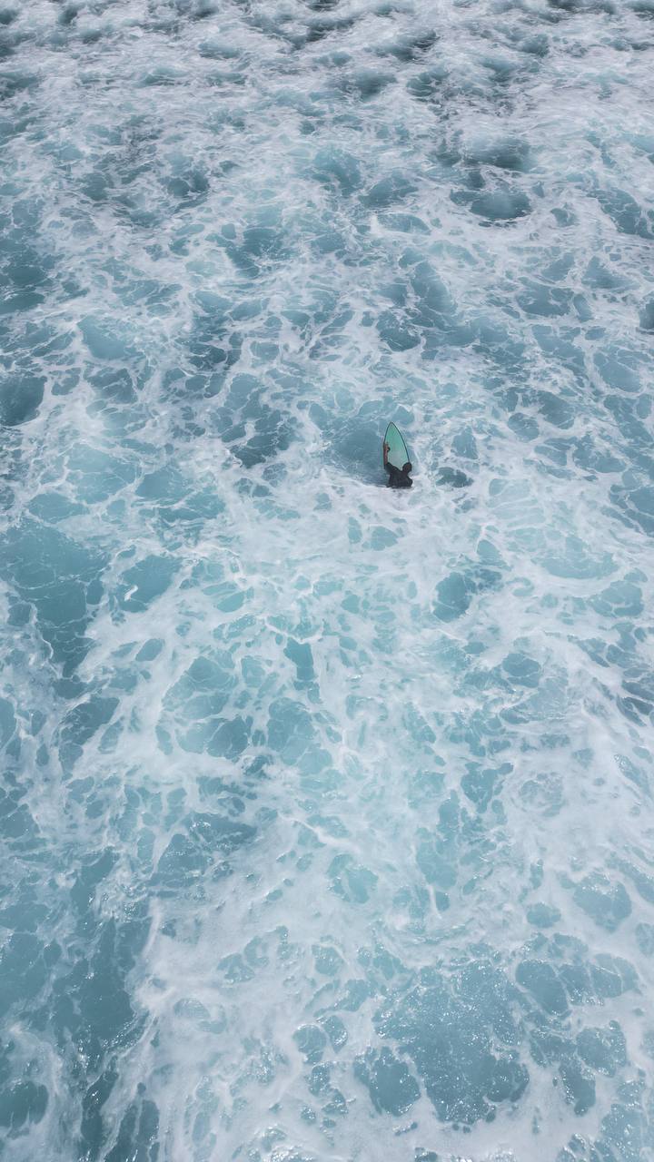 Aerial view of turquoise ocean foam and waves